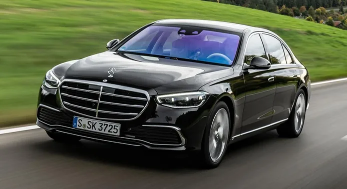 Xe sedan hạng sang màu đen đang chạy trên đường quốc lộ ven đồi